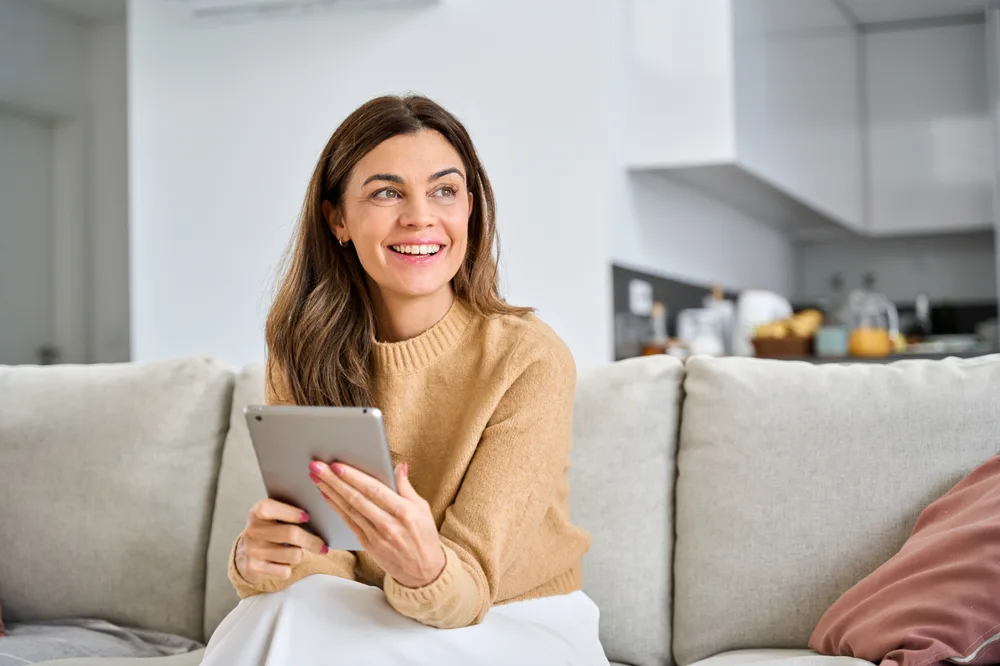 A woman at home holding a tablet